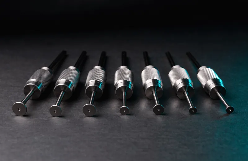 Set of hand-held surgical micro punches of different diameters on dark slate